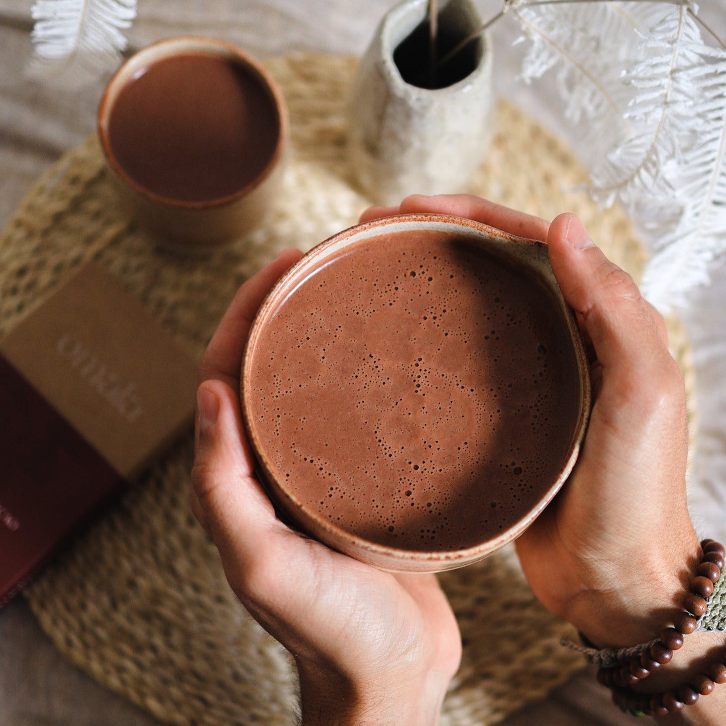 Holding a ceramic mug of Omala ceremonial Cacao in a personal ritual.